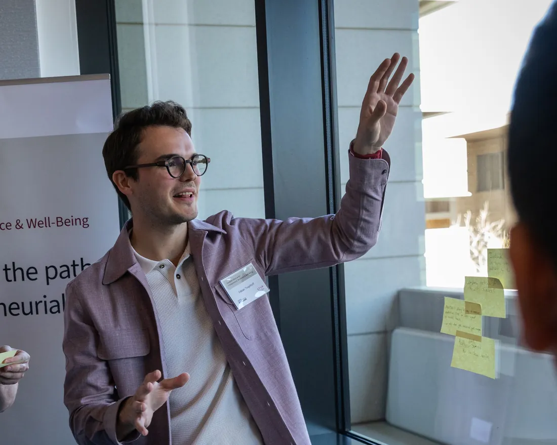 Fabian Tingelhoff explaining workshop results next to sticky notes on a window